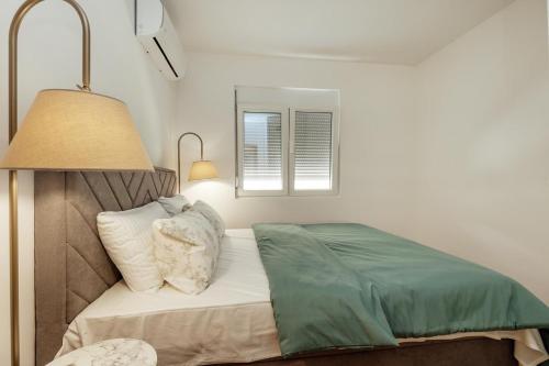 a bedroom with a bed and a lamp and a window at Bella Vista Luxure Apartments in Baošići