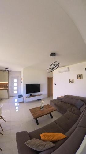 a living room with a couch and a table at Poolhouse Flip Flop - mit privatem Pool in Vir