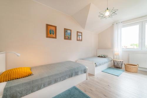 sypialnia z dwoma łóżkami i oknem w obiekcie APARTAMENTY ZATOKA w Jastarni
