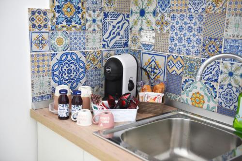 - un comptoir de cuisine avec évier et carrelage bleu et blanc dans l'établissement La Terrazza sugli dei 2, à Agerola
