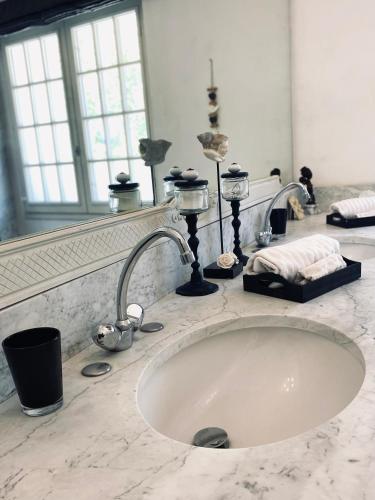 un lavabo de salle de bain avec deux robinets et un miroir dans l'établissement Château Suite, à Saint-Marcel