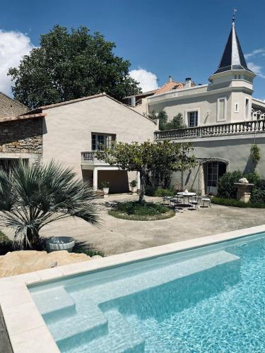 une maison avec une piscine devant une maison dans l'établissement Château Suite, à Saint-Marcel