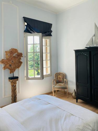 une chambre avec un lit, une chaise et une fenêtre dans l'établissement Château Suite, à Saint-Marcel