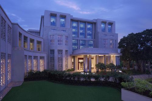 a large building with a green lawn in front of it at Taj Santacruz in Mumbai