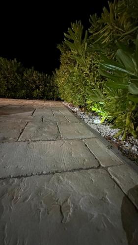 a stone walkway with plants on the side of a street at Poolhouse Flip Flop - mit privatem Pool in Vir