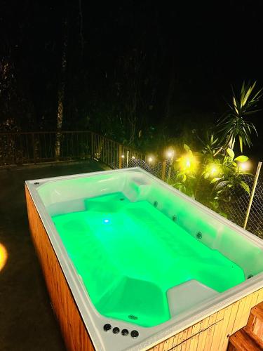 a jacuzzi tub in a backyard at night at Riverside La Masía Ecohotel in Quindío