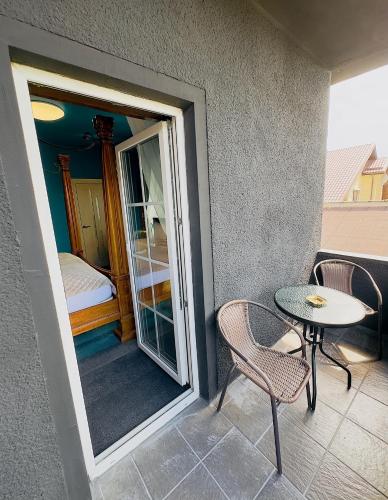 a balcony with a table and chairs and a bedroom at Broken bed hootel in Kaunas