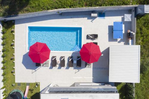 uma vista superior de uma casa com dois guarda-chuvas vermelhos em Villa Edis em Pula