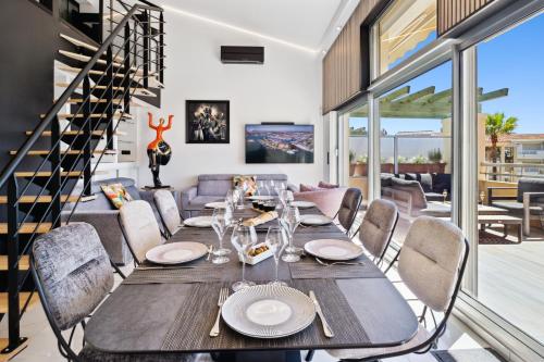 a dining room with a table and chairs and a staircase at DUPLEX VILLA LES PINS 89m2 et terrasse 30m2 in Antibes