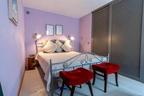 sypialnia z łóżkiem i 2 czerwonymi krzesłami w obiekcie Hause Virgo w mieście Samotraka