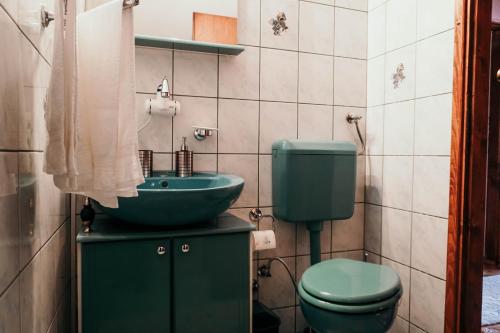 a bathroom with a green toilet and a sink at 3-Bedroom Residence - Prime Location with City View and Parking in Sarajevo