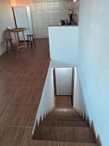 a staircase in a room with a table and a counter at CABO FRIO, SUITES PÉ AREIA in Cabo Frio