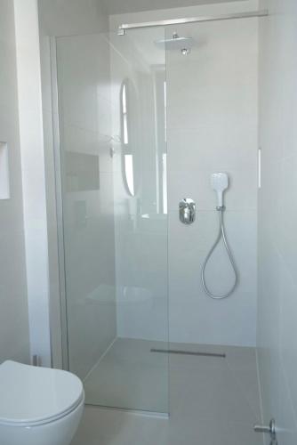 a bathroom with a glass shower with a toilet at CASA V BENCUN Deluxe Queen Rooms in Kiseljak