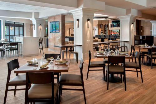 a restaurant with tables and chairs and a bar at Boston Marriott Peabody in Peabody
