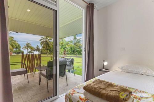 モーレア島にあるSeaside Paradise Retreat - 3BR House in Mooreaのベッドルーム1室(ベッド1台付)、パティオ(テーブル付)