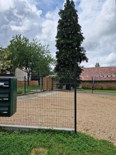 a chain link fence with a tree behind it at L'Escale Nobilienne in Nouaillé-Maupertuis