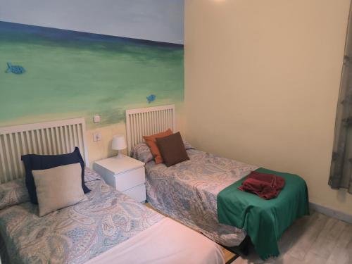 a bedroom with two beds and a painting on the wall at La Puebla in Ponferrada