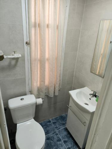 a bathroom with a white toilet and a sink at La Puebla in Ponferrada
