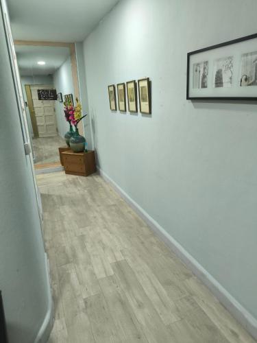 a hallway with white walls and wood floors and pictures at La Puebla in Ponferrada