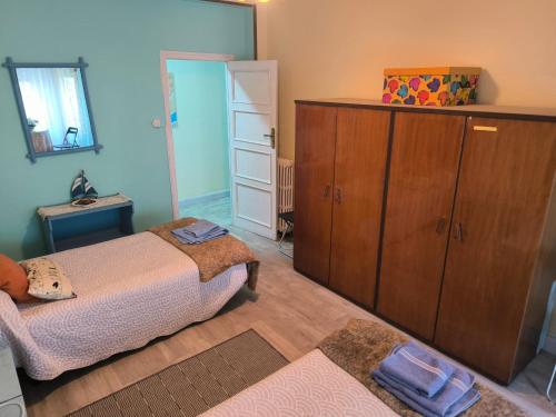 a bedroom with two beds and a large wooden cabinet at La Puebla in Ponferrada