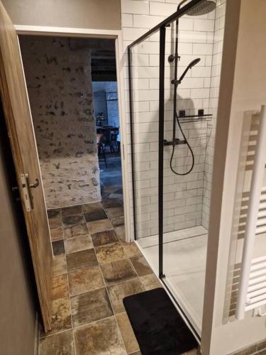 a bathroom with a walk in shower and a glass door at L'Escale Nobilienne in Nouaillé-Maupertuis