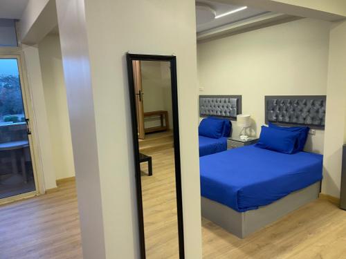 a bedroom with a blue bed and a mirror at Pyramids View Inn in Cairo