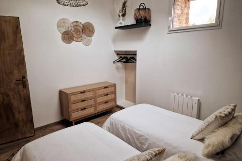 a bedroom with two beds and a dresser and a window at L'Escale Nobilienne in Nouaillé-Maupertuis