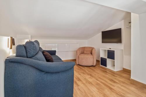 a living room with a blue couch and a tv at DUPLEX VILLA LES PINS 89m2 et terrasse 30m2 in Antibes