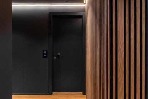 a black elevator door in a room with wood paneling at Levelup in Treviso