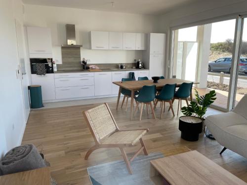 une cuisine et un salon avec une table et des chaises dans l'établissement Appartement neuf centre station a 200m de la plage, à Neufchâtel-Hardelot
