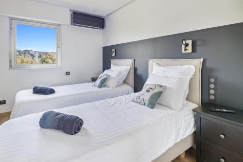 two beds in a room with a window at DUPLEX VILLA LES PINS 89m2 et terrasse 30m2 in Antibes