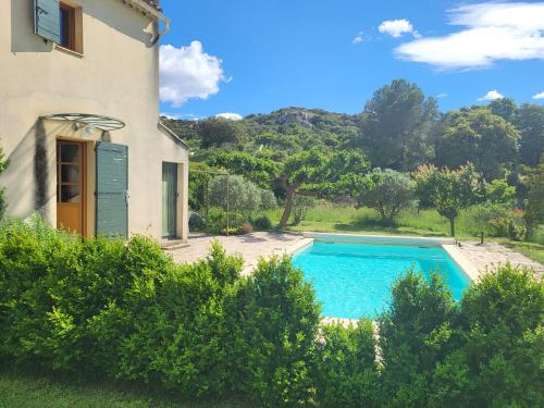 une villa avec piscine devant une maison dans l'établissement Villa vue sur la Garrigue avec piscine, à Valliguières