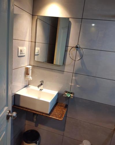 a bathroom with a white sink and a mirror at Hotel Grand Bella in Mumbai