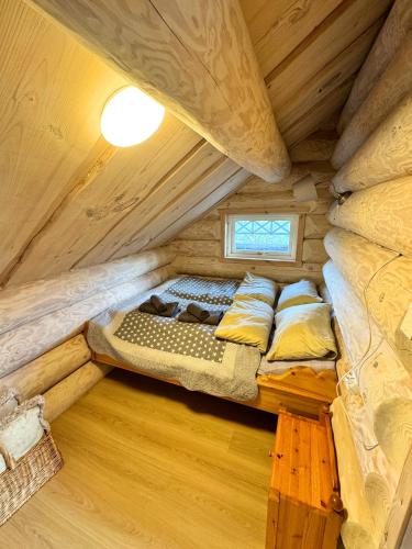 a bedroom in a log cabin with a bed at Unique Arctic Timber Cabin in Skaidi