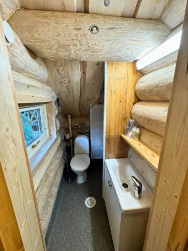 a small bathroom with a toilet and a sink at Unique Arctic Timber Cabin in Skaidi