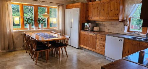 a kitchen with a table and chairs in a kitchen at Fully equipped house in the countryside at Knohult in Aneby