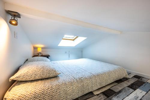 une chambre avec un lit et une lucarne dans l'établissement Cosy and Quite, à Bidart