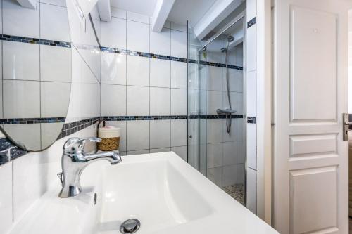 une salle de bain avec un lavabo, un miroir et une douche dans l'établissement Cosy and Quite, à Bidart