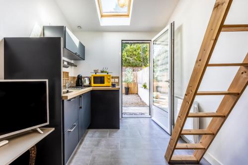 une cuisine avec une échelle menant à une porte dans l'établissement Cosy and Quite, à Bidart