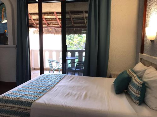 a bedroom with a bed with a view of a patio at Chez Waffle Hotel in Puerto Aventuras