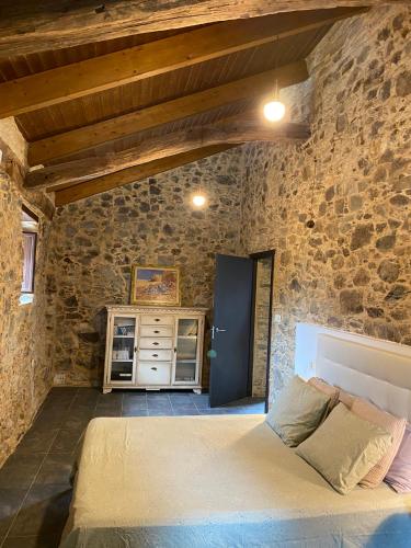 a bedroom with a bed in a stone wall at CASA PEINADO in Boimorto