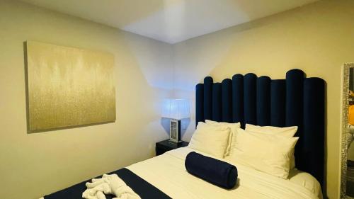 a bedroom with a bed with a large blue headboard at Cozy apartment with terrace, SJ Cosmopolitan Tower #402 in San José