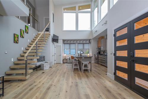 a large living room with stairs and a kitchen at Skyview Oasis Modern Build 1 Mile from Downtown Black Mtn! in Black Mountain