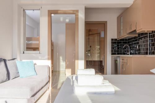 a living room with a white couch and a kitchen at Art Studios in Neos Marmaras