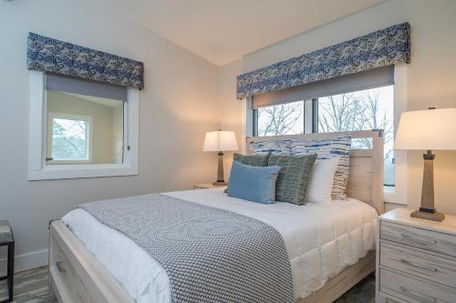 a bedroom with a large bed with two windows at Skyview Oasis Modern Build 1 Mile from Downtown Black Mtn! in Black Mountain