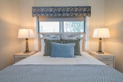a bedroom with a bed with two lamps and a window at Skyview Oasis Modern Build 1 Mile from Downtown Black Mtn! in Black Mountain
