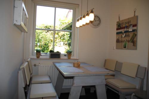 a room with a table and chairs and a window at Fenneluca, Den Hoorn in Den Hoorn