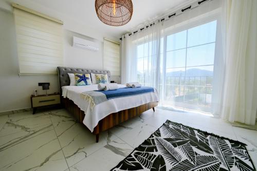 une chambre avec un lit et une grande fenêtre dans l'établissement Green Hills Luxury Villa Fethiye, Yesiluzumlu by Sunworld Villas, à Fethiye