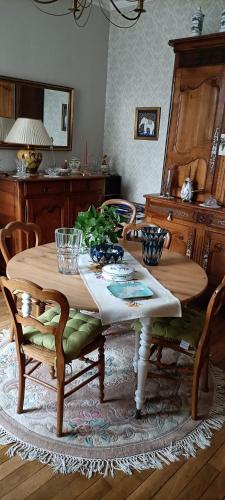 - une table et des chaises en bois dans l'établissement agréables chambres d'hôtes près du centre ville avec jardin, au Mans