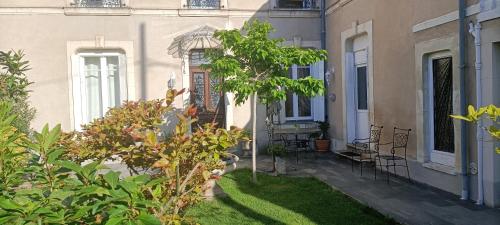 a house with a yard with chairs and plants at agréables chambres d'hôtes près du centre ville avec jardin in Le Mans